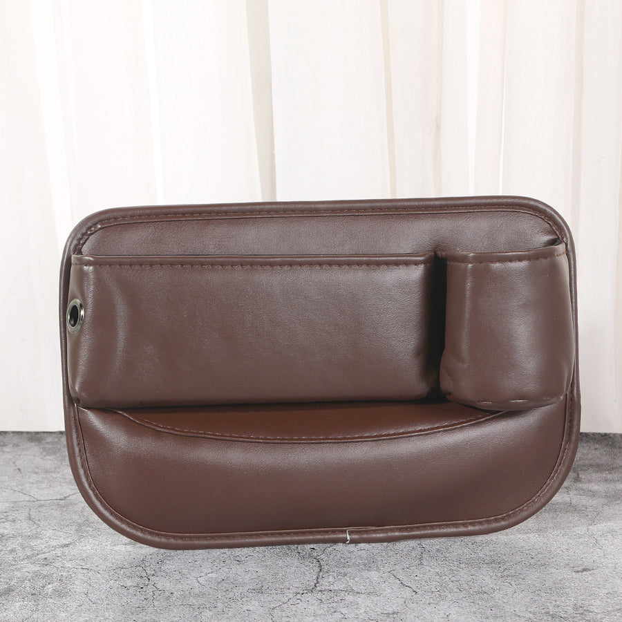 Angled studio shot of black car seat gap filler organizer highlighting durable faux leather texture and reinforced stitching