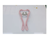 Pink manual neck massager with thumb-shaped silicone pressure nodes