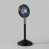 Sleek matte black sunset projector lamp on light-gray studio background showing crystal optical