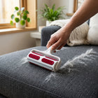 Reusable pet hair remover roller picking up cat and dog fur from dark grey couch fabric