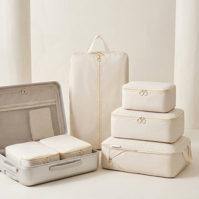 IntelWink Ultra-Compression Travel Packing Cubes Set stacked neatly with suitcase in bright studio